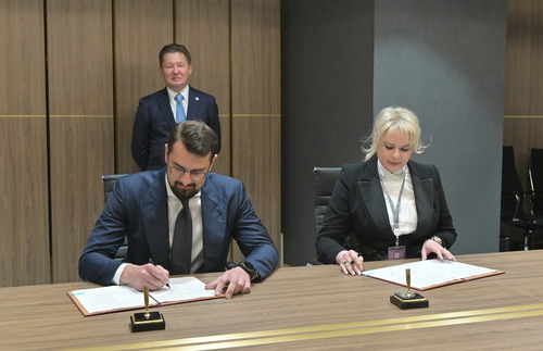 Николай Запрягаев и Любовь Бриш во время подписания, на заднем плане — Алексей Миллер
